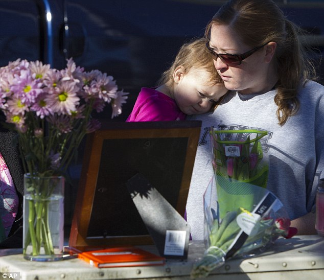 Memorial" Bonnie Davies and her toddler daughter, Isabella Davies, pay their respect in Springfield on Monday