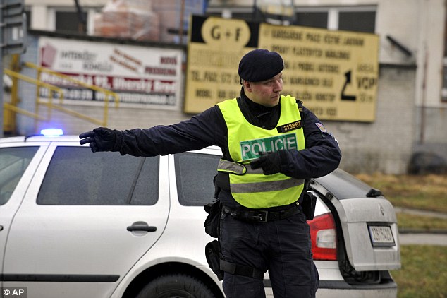 A police officer directs traffic away from the restaurant where the shooter opened fire killing eight people 