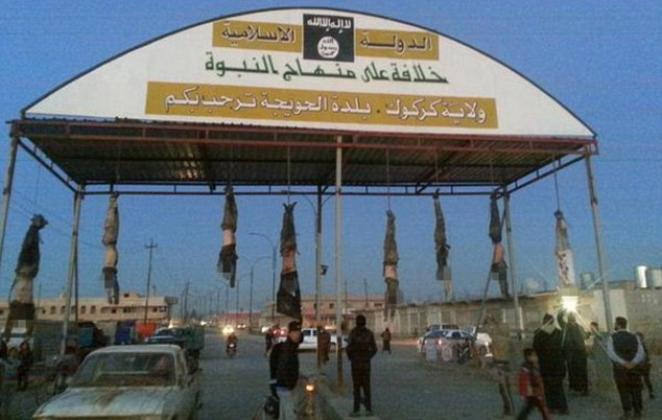 Welcome to Hell: ISIS hang bodies of 'soldiers' from entrance to the city where Syrian troops were paraded through streets in cages
